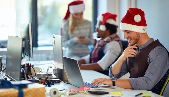 Junger Mann bei Weihnachtsfeier im Büro