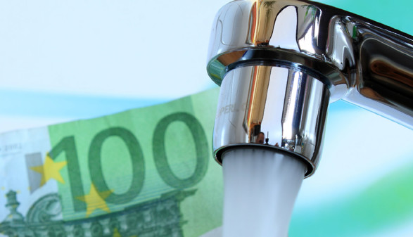 Wasserhahn mit 100-Euro-Schein im Hintergrund