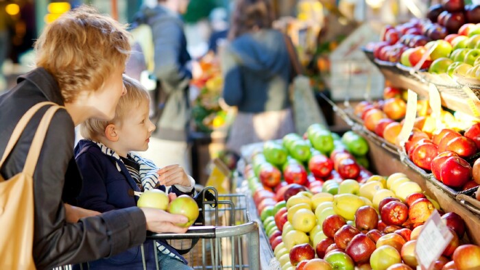Mama und Sohn kaufen Obst auf einem Bauernmarkt