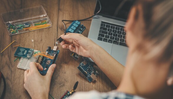 Junge Frau repariert einen Laptop.