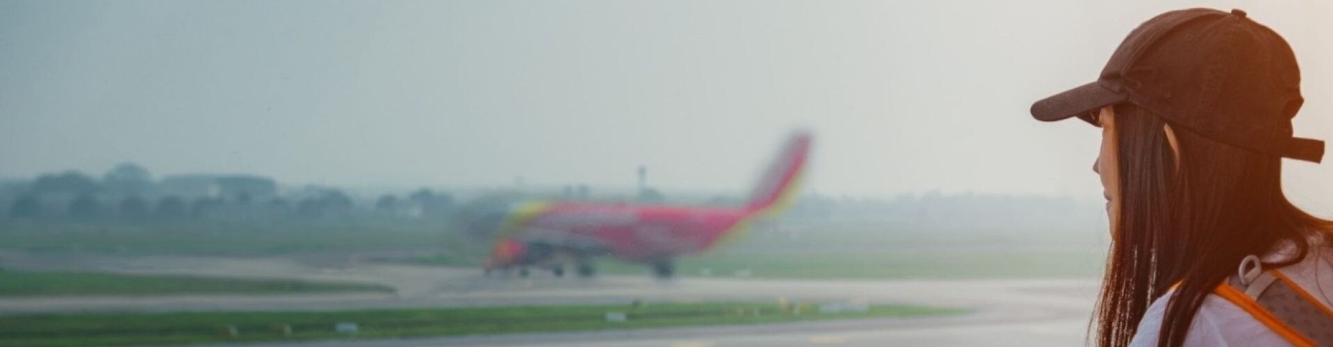 Reisende blickt vom Flughafen in Richtung Flugzeug