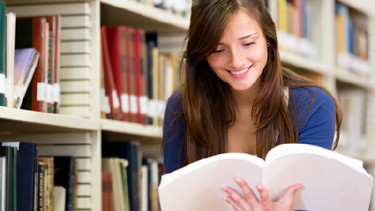 Studentin informiert sich in der Bibliothek