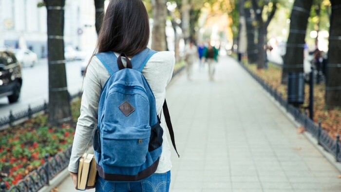 Back view portrait of a female student walking