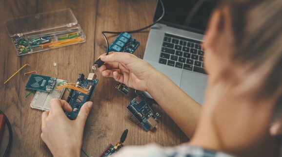 Junge Frau repariert einen Laptop.