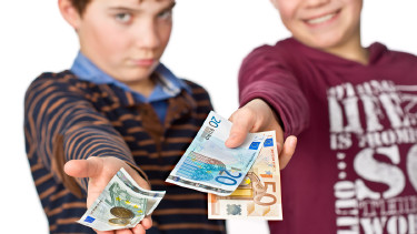 Zwei Kinder halten Bargeld in der ausgestreckten Hand. Eines der beiden hat deutlich mehr als das andere. © Markus Bormann, stock.adobe.com