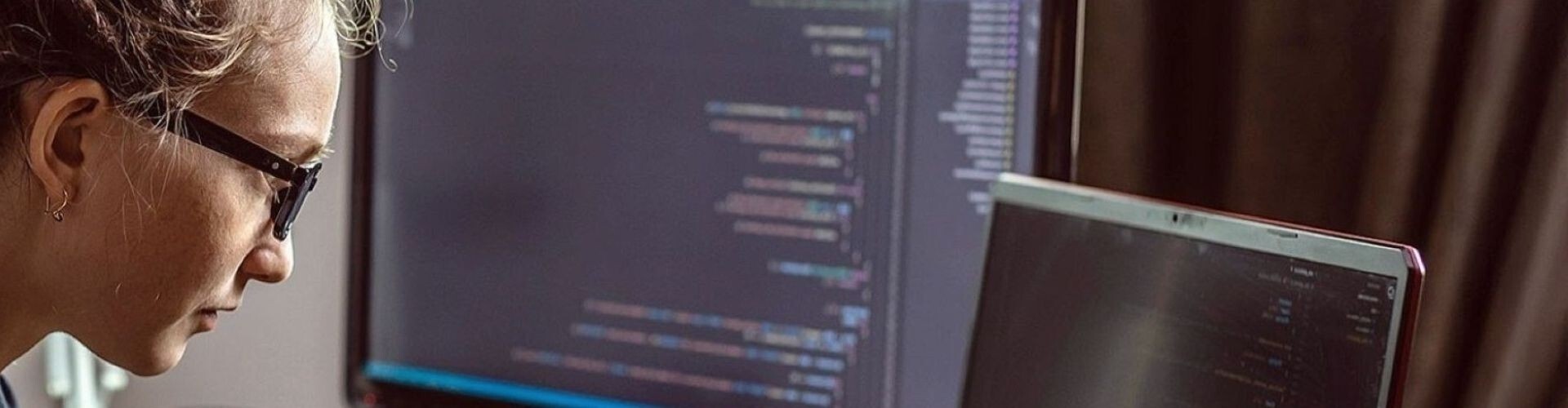 Eine junge Programmiererin schreibt einen Programmcode auf ihrem Laptop