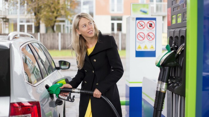 Frau tankt Auto mit Benzin