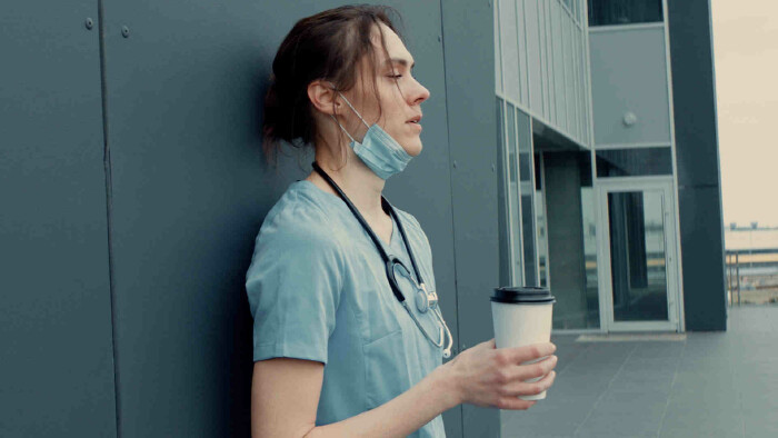 &Uuml;berm&uuml;dete Krankenschwester mit Kaffee in der Pause