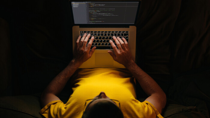 Junger Mitarbeiter schreibt am Laptop spät in der Nacht. © Arsenii, stock.adobe.com