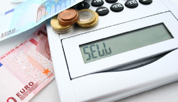 Auf einem Tisch liegen Geldscheine, Münzen und ein Tischrechner, auf dessen Display "Sell" geschrieben steht © foodinaire, stock.adobe.com