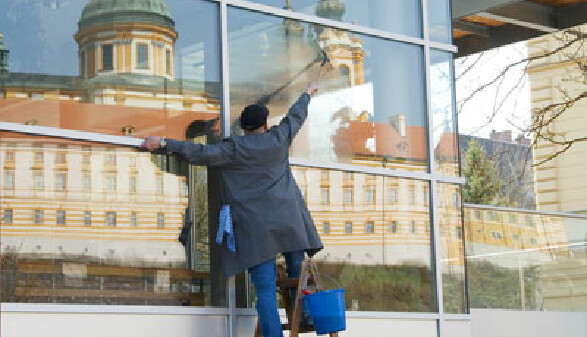 Reinigungskraft beim Fensterputzen