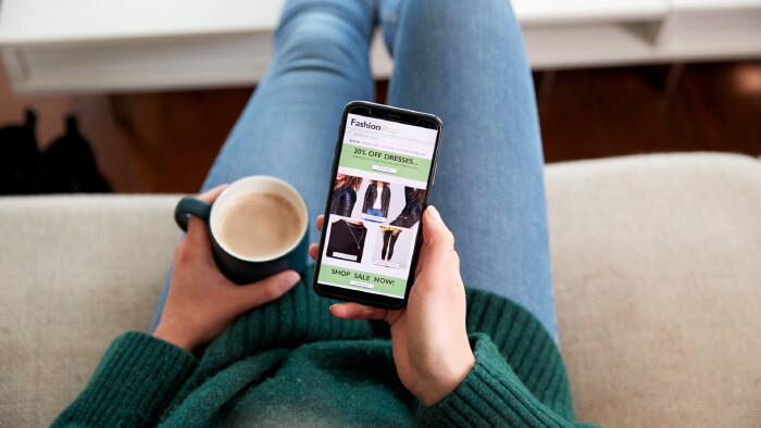 © Monkey Business, stock.adobe.com Nahaufnahme einer Frau, die mit der Handy-App online Kleidung kauft
