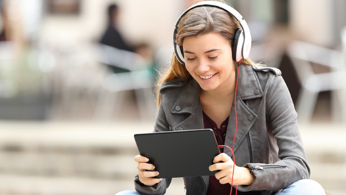 Frau sieht auf Tablet und benützt ein HeadSet