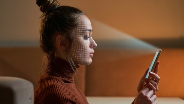 © Goffkein, stock.adobe.com Eine Frau scannt das Gesicht mit einem Gesichtserkennungssystem auf dem Smartphone zur biometrischen Identifizierung.