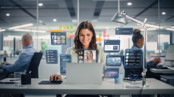© Gorodenkoff, stock.adobe.com Junge Angestellte mit Laptop und Kolleg:innen im Büro