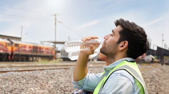 Arbeiter trinkt Wasser aus einer Flasche