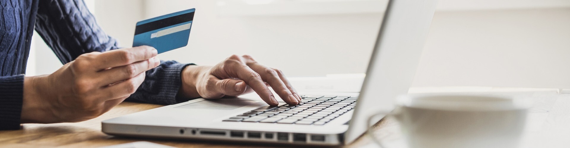  Frau mit Laptop und Kreditkarte und in der Hand