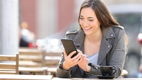 Junge Frau schaut auf ihr Smartphone