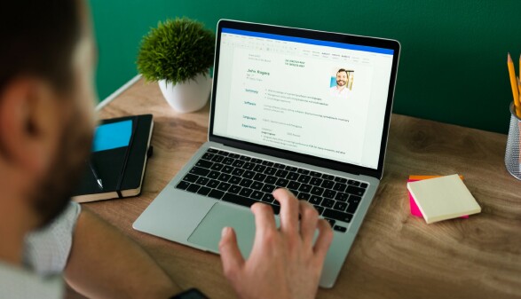 Junger Mann schreibt am Tablet seinen Lebenslauf.