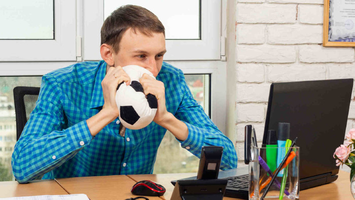 © madhourse, stock.adobe.com Mann vor Laptop im Büro mit Fußball in den Händen © madhourse, stock.adobe.com