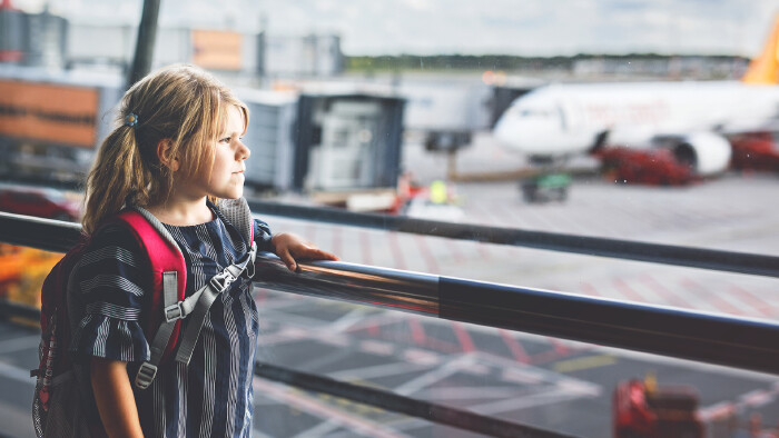 Little girl at the airport waiting for boarding at the big window.  © Irina Schmidt, stock.adobe.com