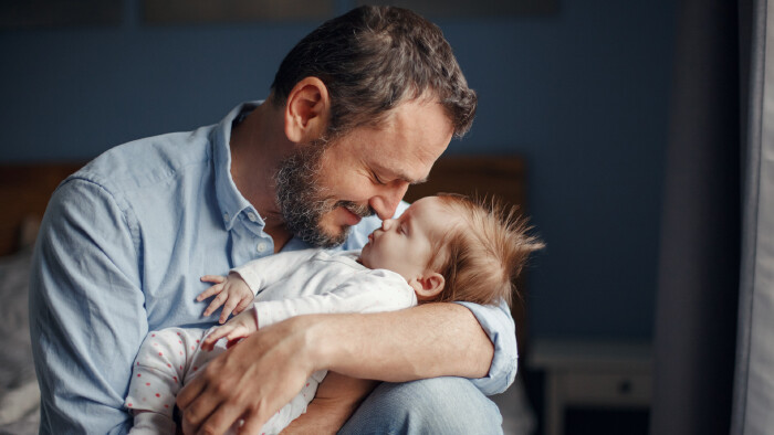 Vater hält Baby im Arm