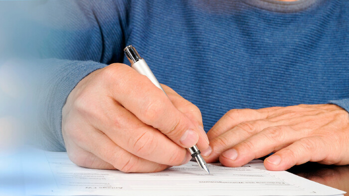 Mann unterschreibt Antrag