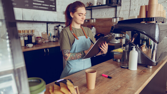 Junge Kellnerin mit Clipboard