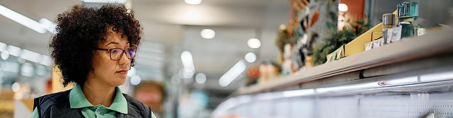 Portr&auml;t einer selbstbewussten Verk&auml;uferin im Supermarkt und Blick in die Kamera