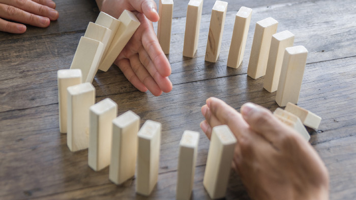 © doidam10- stock.adobe.com fallende Dominosteine, die aufgehalten werden © doidam10- stock.adobe.com