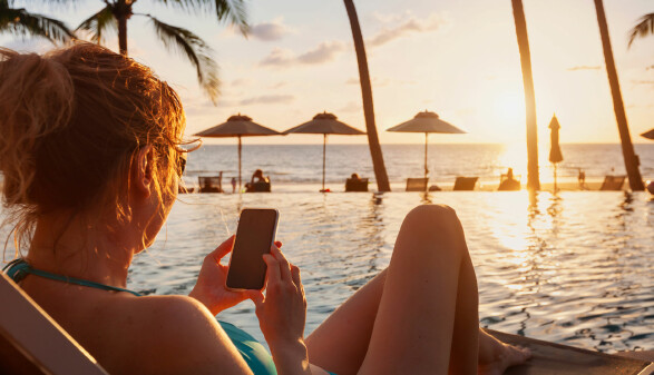 Frau surft im Urlaub am Handy