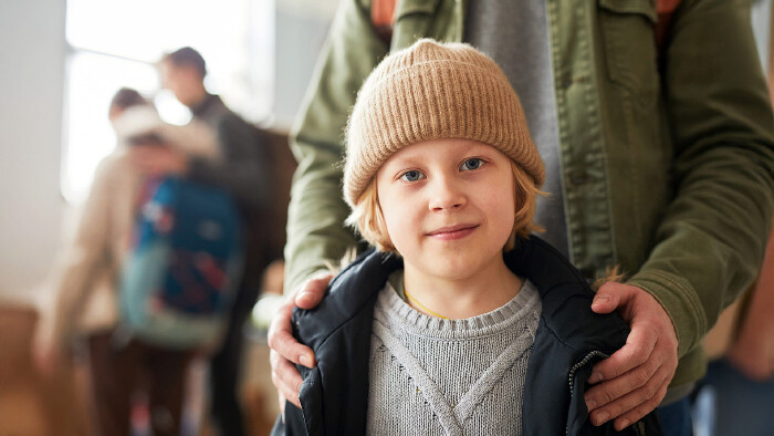 © Seventyfour, stock.adobe.com Junger Bub und sein Vater in einem Hilfszentrum für Flüchtlinge