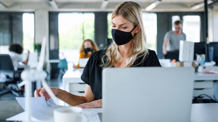 © Halfpoint, stock.adobe.com Frau mit Maske am Arbeitsplatz © Halfpoint, stock.adobe.com