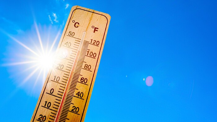 Sommerhintergrund - blauer Himmel mit strahlender Sonne und Thermometer
