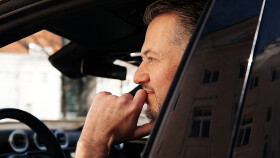 Junger Mann sitzt in seinem Auto