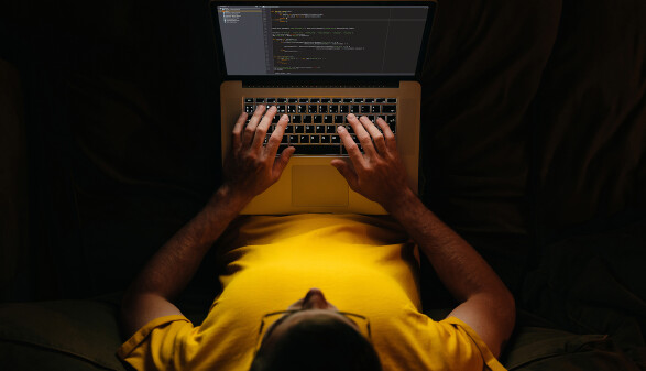 Junger Mitarbeiter schreibt am Laptop spät in der Nacht. © Arsenii, stock.adobe.com