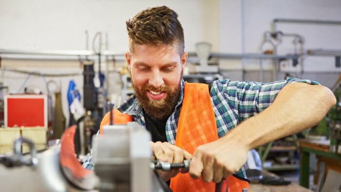 Junger Arbeiter beim Schrauben