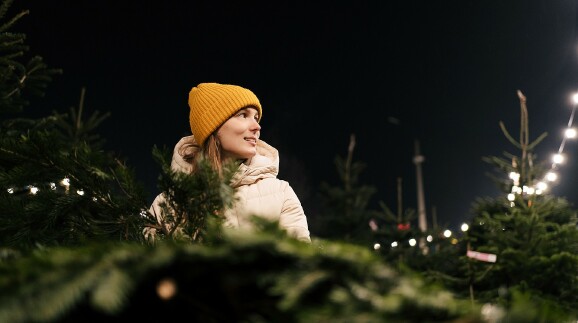 Junge Frau verkauft Weihnachtsb&auml;ume